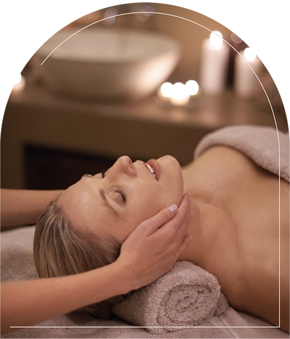 Kobieta relaksująca się podczas masażu twarzy w salonie spa.